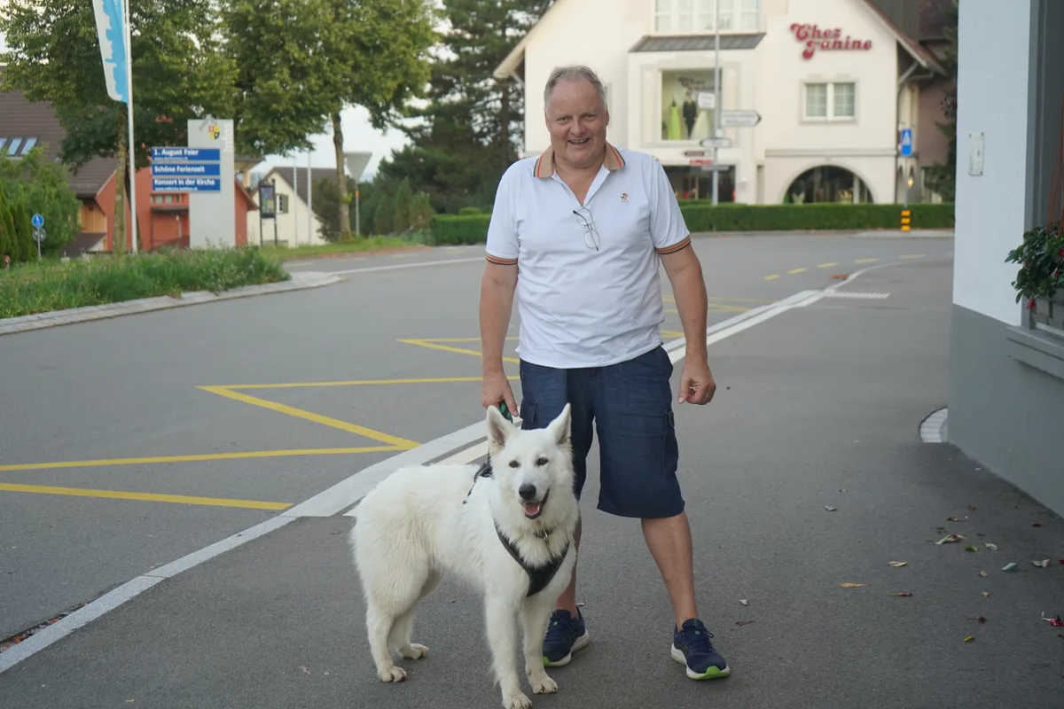 Paul Nauer steht mit einem weissen Hund auf einer Strasse in Bubikons Zentrum.
